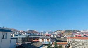 Blick auf eine Stadt mit Dächern und Gebäuden in der Unterkunft Shangri-La Jilaideng Gucheng Hotel in Shangri-La