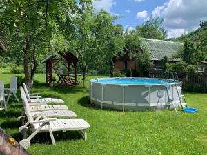 a group of chairs and a pool in a yard at Sadyba Lesivykh in Slavske