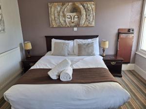 a bedroom with a large bed with two towels on it at The Cambrian in New Quay