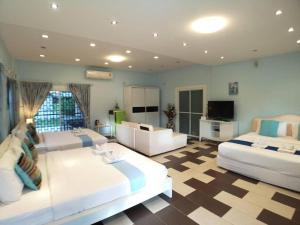 Cette grande chambre comprend deux lits et une télévision. dans l'établissement Chiangkhan Gallery Resort, à Chiang Khan