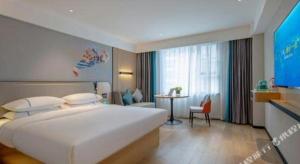a bedroom with a large white bed and a table at City Comfort Inn Guangzhou Baiyun Mountain in Guangzhou +206 photos