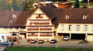 un gran edificio con coches estacionados frente a él en Gästehaus Krone, en Schönengrund