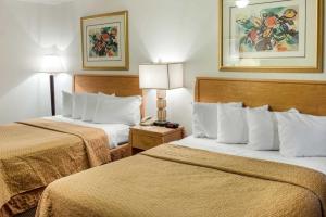 a hotel room with two beds and a telephone at Quality Inn in Albuquerque