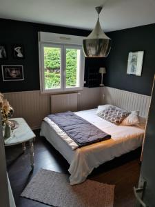 a bedroom with a large bed and a window at La Villa du Teich in Le Teich