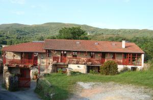 ein großes Haus mit rotem Dach auf einem Hügel in der Unterkunft A Casa da Eira in Cerreda