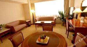 une chambre d'hôtel avec une table et des fruits dans l'établissement Noble Jasper Hotel Huizhou, à Huizhou