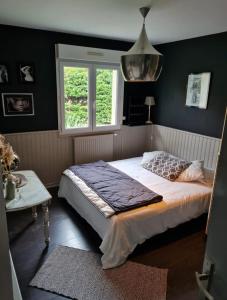 a bedroom with a large bed and a window at La Villa du Teich in Le Teich