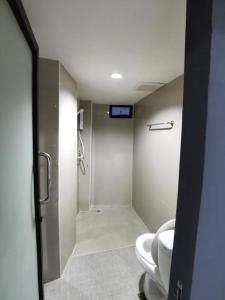 a bathroom with a toilet and a walk in shower at Poompimaan House in Udon Thani