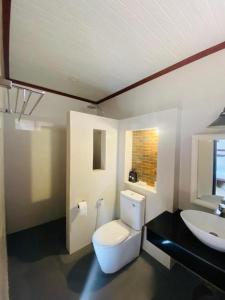 ein Badezimmer mit Toilette und Waschbecken in der Unterkunft Alongkot Beach Resort Khanom in Ban Phang Phrao