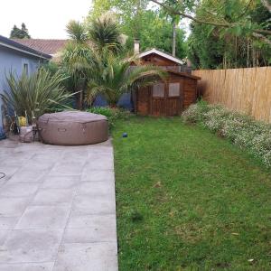 einen Hinterhof mit Whirlpool im Gras in der Unterkunft Superbe maison avec Spa en direct in Le Haillan