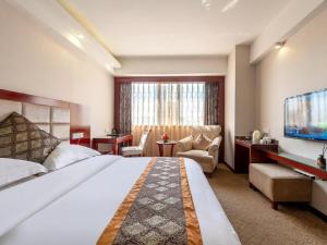 a hotel room with a large bed and a television at Overseas Chinese Hotel in Zhuhai +209 photos