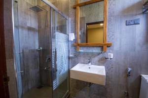 une salle de bain avec un lavabo et une douche en verre dans l'établissement Hill Pride City Hotel, à Nuwara Eliya 49 autres photos