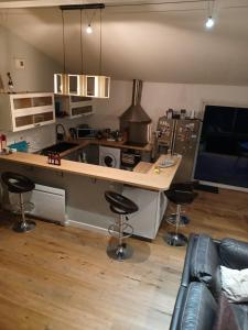 eine Küche mit einer Theke und einigen Barhockern in der Unterkunft Superbe maison avec Spa en direct in Le Haillan