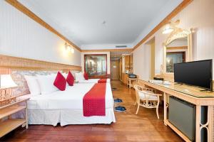 a hotel room with a large bed and a desk at Senriver Hotel in Da Nang
