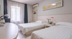 una camera d'albergo con due letti e una finestra di Jinjiang Inn Wuxi Li Lake Yauntouzhu Scenic Spot a Wuxi