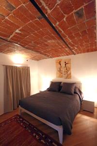 1 dormitorio con 1 cama con techo de ladrillo en Alba sui Tetti apartment, en Alba