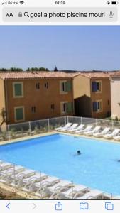 a picture of a pool with a person in the water at Maison dans une residence fermée in Mouriès