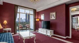 a living room with red walls and a room with a tv at Country Garden Phoenix Hotel Changsha in Xingsha