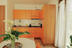a kitchen with orange cabinets and a table at Casa Rudy, Villa on Lake Como in Colico