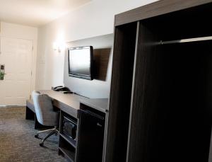a room with a desk with a computer and a television at Quality Inn & Suites Lathrop in Lathrop