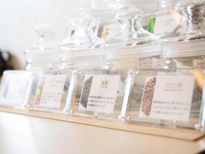 Un estante lleno de frascos de vidrio transparente con etiquetas. en Comfort Hotel ERA Tokyo Higashi Kanda, en Tokio