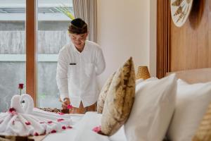 a woman standing next to a bed in a room at Badawa Ubud Villa in Ubud +134 photos