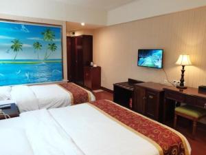 a hotel room with two beds and a desk at GreenTree Alliance Guangdong Shenzhen Pinghu Avenue Jingdu Town Hotel in Tiantangwei