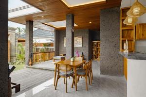 a kitchen and dining room with a wooden table and chairs at Badawa Ubud Villa in Ubud