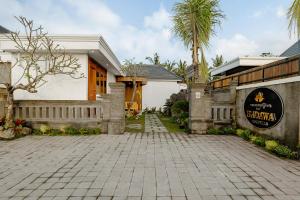 a house with a brick driveway in front of a building at Badawa Ubud Villa in Ubud