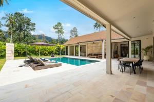 an outdoor patio with a table and a swimming pool at Villa Mangosteen spacious 3br Pool villa in Ban Thung