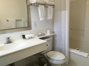 a bathroom with a toilet and a sink and a mirror at La Avenida Inn in San Diego