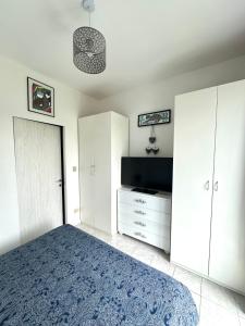 a bedroom with white cabinets and a bed and a tv at Maison Elsa in San Vito Chietino