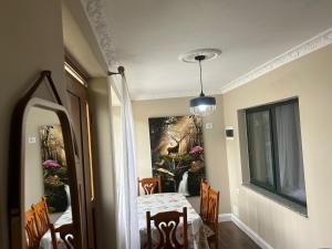 a dining room with a table and a painting on the wall at Ndregjoni Albanian Village House near Tirana in Klos