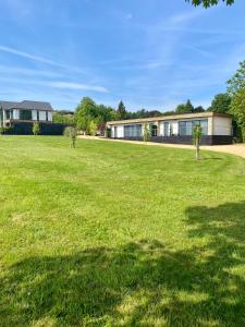 a large grassy field in front of a building at The Orchard Retreat in Bath +35 photos
