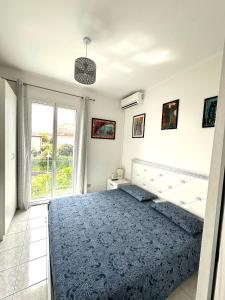 a bedroom with a blue bed and a window at Maison Elsa in San Vito Chietino