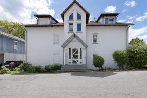 a white house with a door in a driveway at Ferienwohnung Seeoase in Markelfingen