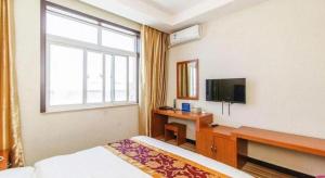 北京市にある169 Business Hotelのベッドと机とテレビがあるホテルの部屋