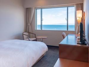 高島市にあるImazu Sun Bridge Hotelのベッドと大きな窓があるホテルの部屋