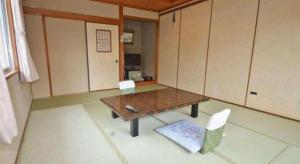 Una habitación con una mesa y dos sillas y armarios. en Anori Seaside Hotel, en Ōsasu