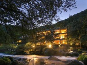 a building with lights in front of a river at Myoken Ishiharaso in Kirishima