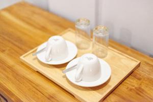 two white dishes on a wooden tray with glasses at Anantalla Homestay in Sidemen +15 photos