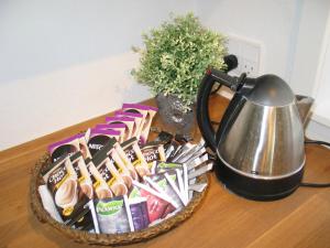 a basket of food on a table next to a tea kettle at Aalborg City Rooms ApS in Aalborg