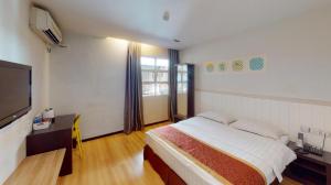 a bedroom with a bed and a flat screen tv at Aston Boutec Hotel Lintas Plaza in Kampong Nasob