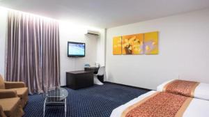 a hotel room with a bed and a couch and a television at Aston Boutec Hotel Lintas Plaza in Kampong Nasob +49 photos