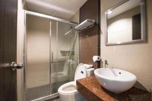 a bathroom with a sink and a toilet and a shower at Aston Boutec Hotel Lintas Plaza in Kampong Nasob