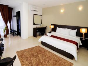 a bedroom with a large bed and a desk at Inn Home Hotel Muar in Kampung Tanjung Agas