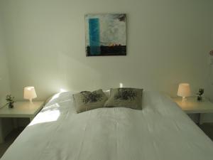 a bedroom with a white bed with two lamps at Aalborg City Rooms ApS in Aalborg
