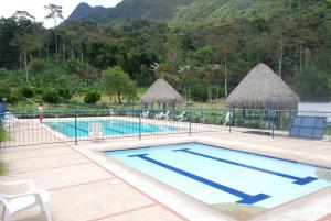 a swimming pool with a pool table and chairs at Finca Las Mercedes in Cumaca