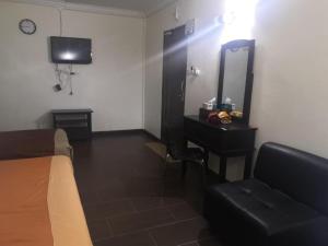 a bedroom with a bed and a desk and a mirror at OYO 90473 Opah Inn Hotel in Jertih