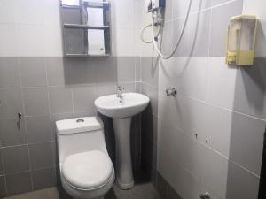 a bathroom with a toilet and a sink at OYO 90473 Opah Inn Hotel in Jertih